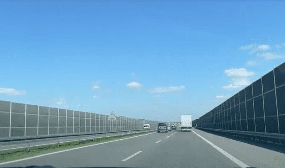 A clear highway with sound barriers on both sides, light traffic, and a bright blue sky with a few clouds&mdash;ideal for exploring the best routes from Krakow to Prague.