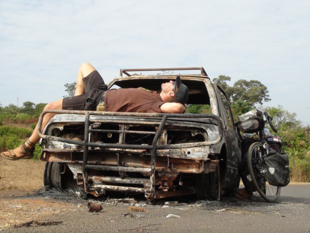 Kayden Kleinhans resting on the bonnet an old burnt out car with his bike leaning against the side | GREEN HOME Kayden Kleinhans resting on the bonnet an old burnt out car with his bike leaning against the side