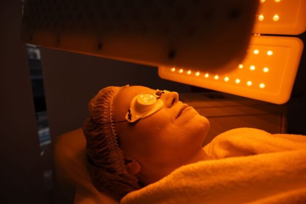 A woman doing led light therapy for skin
