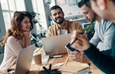 Why Chasing Big Clients Could Be the Death of Your Startup – The Hidden Power of Smaller, Consistent Wins.jpg 2 a group of people sitting around a table