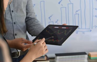 a person holding a tablet with a graph on it