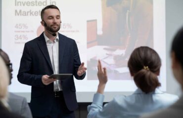 a man in a suit giving a presentation to a woman