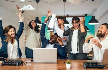 a group of people in a room with a laptop and papers