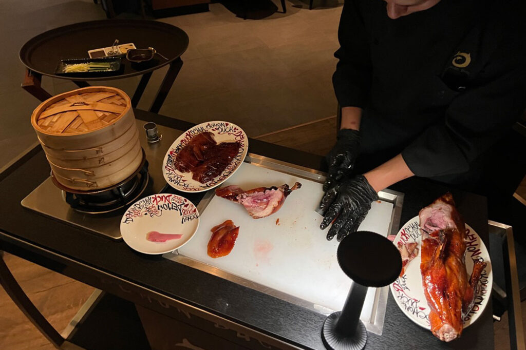 best peking duck in dubai - photo of peking duck being chopped by chef at Demon Duck by Alvin Leung at Banyan Tree hotel, bluewaters dubai
