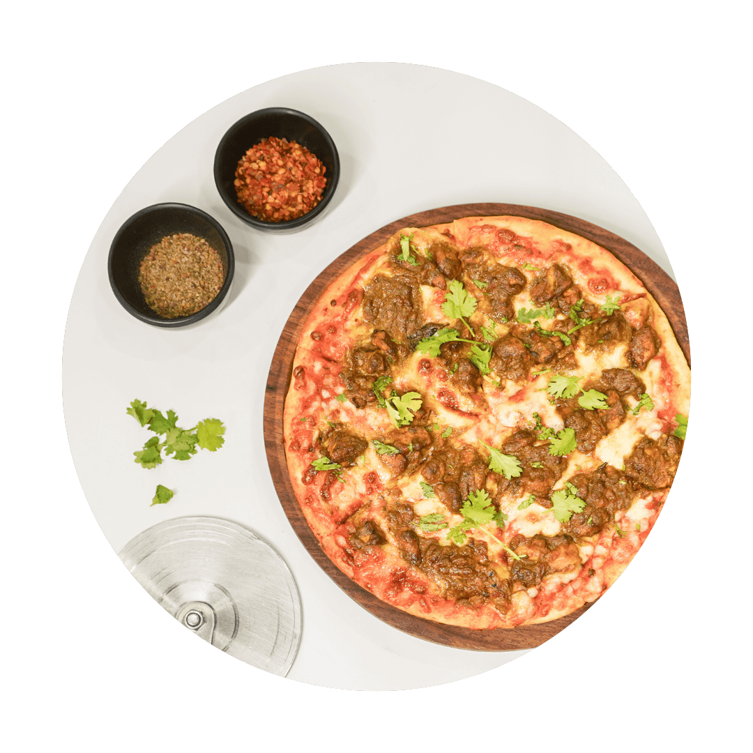 a pizza with sauce and spices on a white table