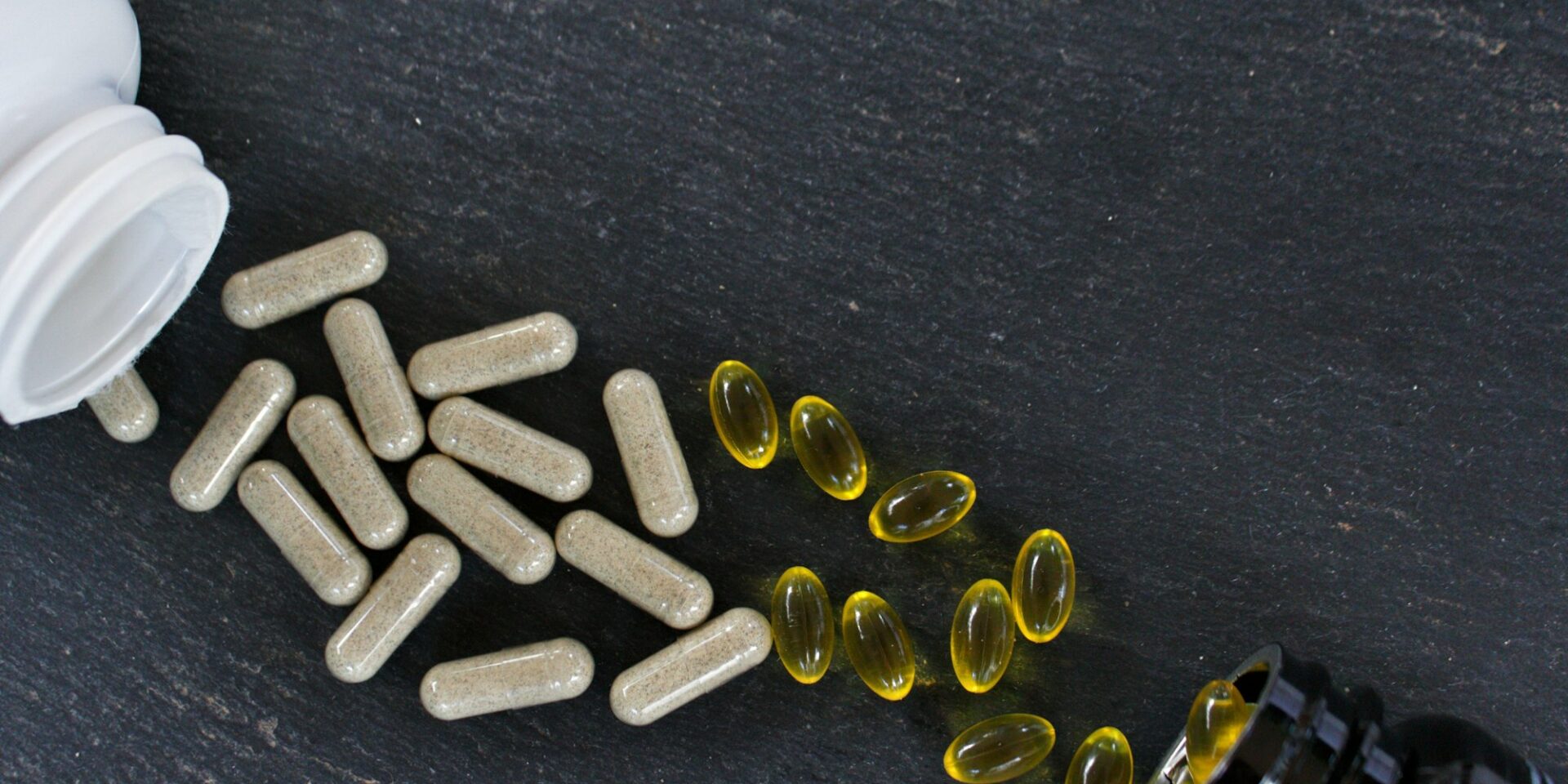 Top view of vitamin supplements on a black surface