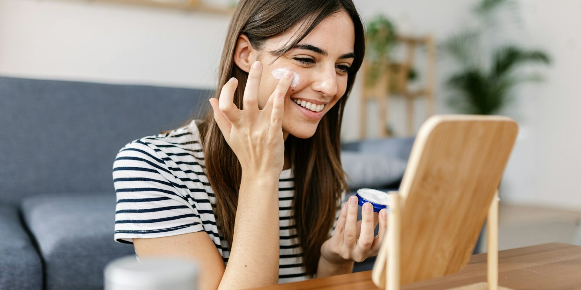 Smiling young pretty woman applying natural skin cream at her face for healthy skin in Meridian Idaho