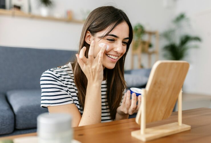 Smiling young pretty woman applying natural skin cream at her face for healthy skin in Meridian Idaho