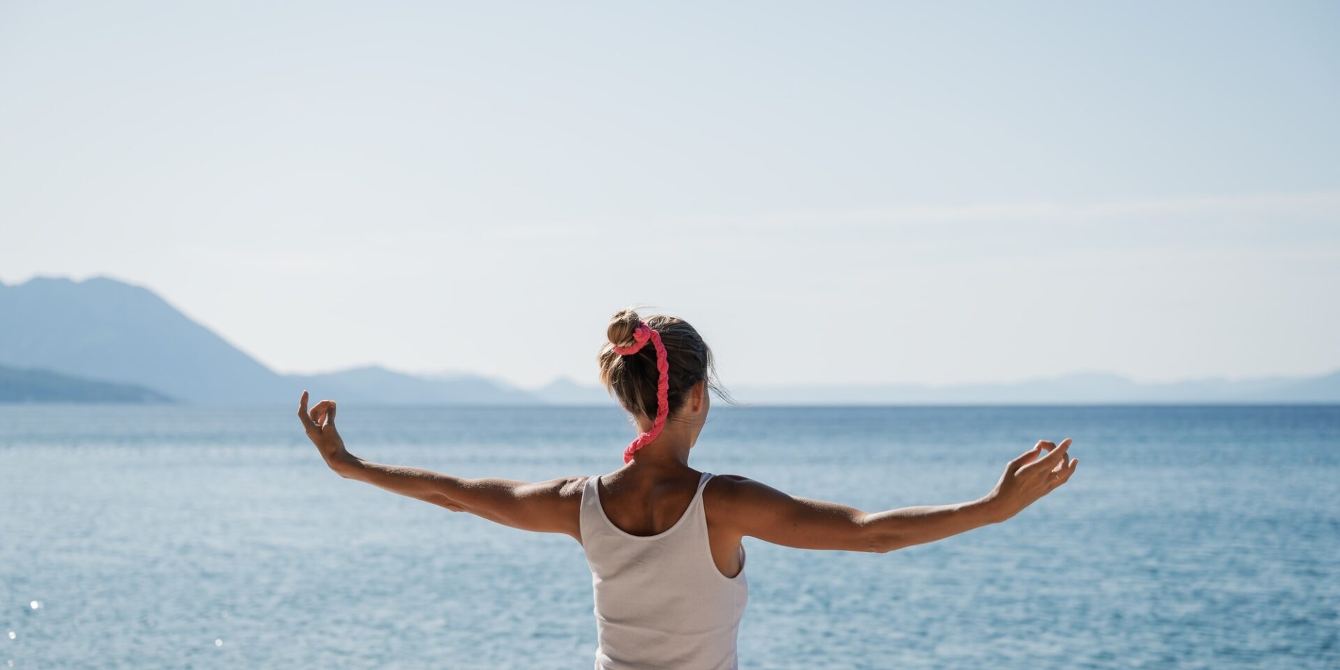 Young woman morning meditation by the sea