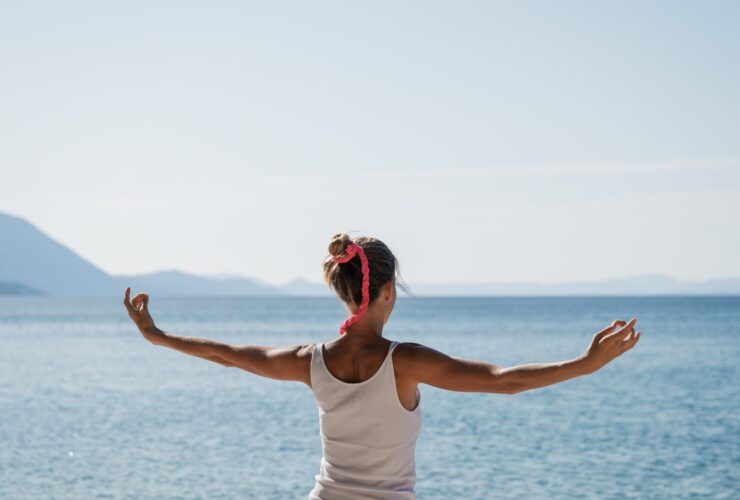 Young woman morning meditation by the sea