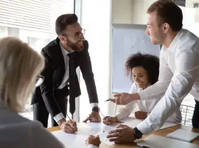 vCIO - ATECHSO - Managed IT Company Enthusiastic business team engaged in a lively discussion around a conference table, signifying collaborative teamwork, corporate strategy meetings, or brainstorming sessions.