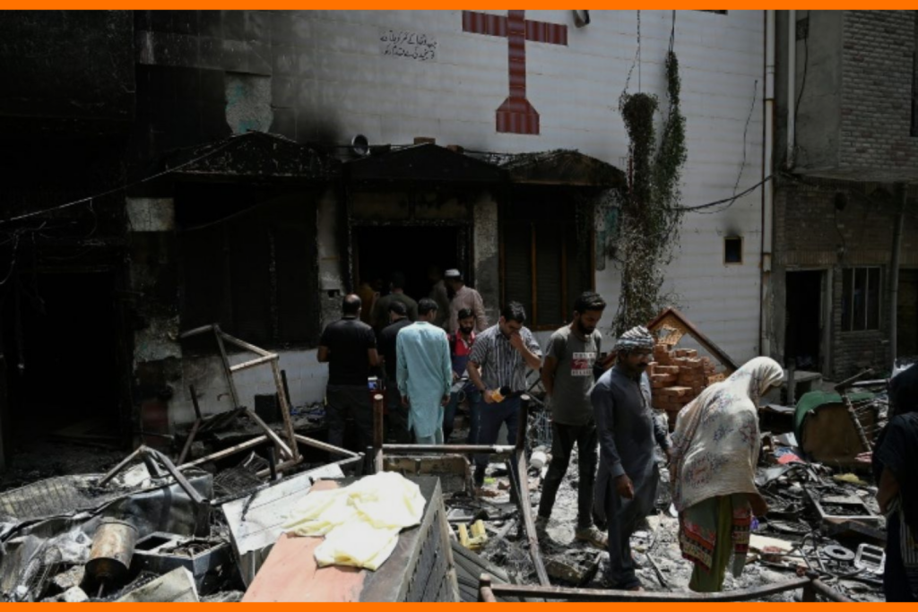 Des policiers et des habitants au milieu des débris de l'église Saint-Jean incendiée à Jaranwala au Pakistan, le 17 août 2023