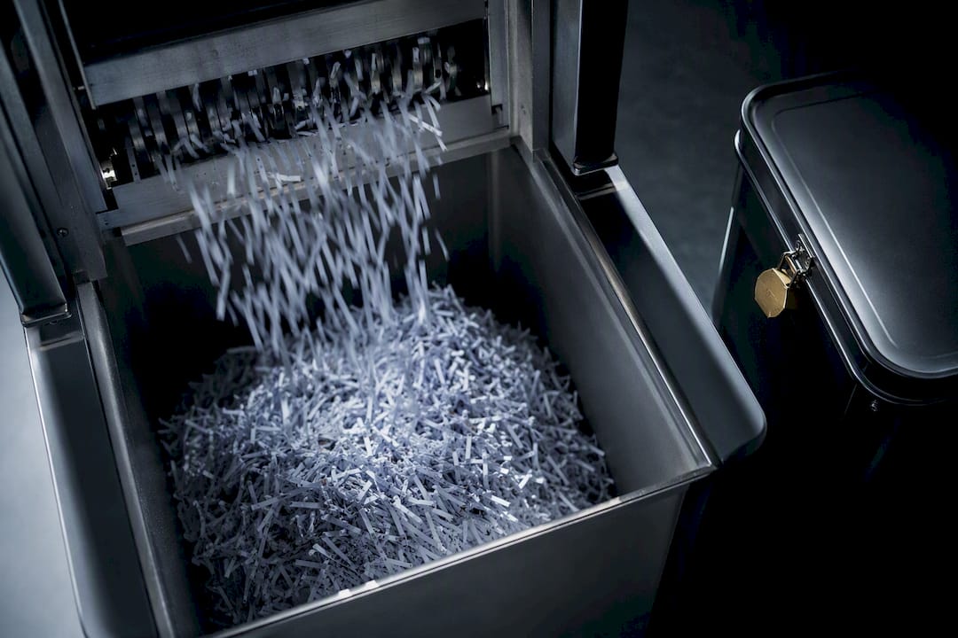 Confidential paper waste entering secure destruction machinery