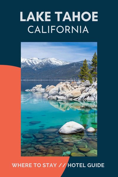 Lake Tahoe with clear water, boulders and snow capped mountains.