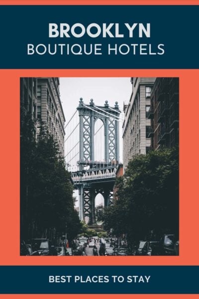 View of the Brooklyn Bridge between buildings.