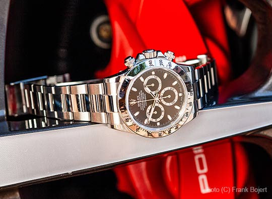 Rolex-Uhr auf einer Porsche-Felge liegend