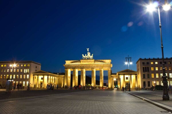 Brandenburg Gate at night with a deep blue sky.