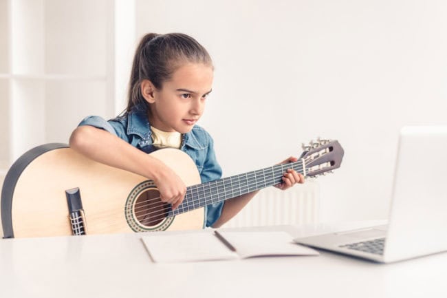 focused girl practicing guitar