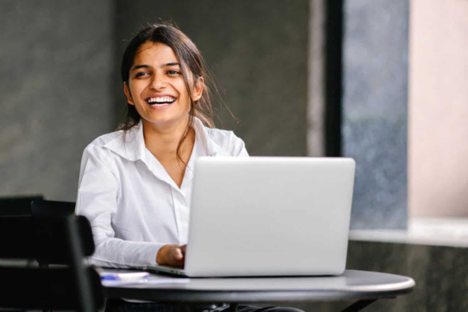 Laughing woman with laptop