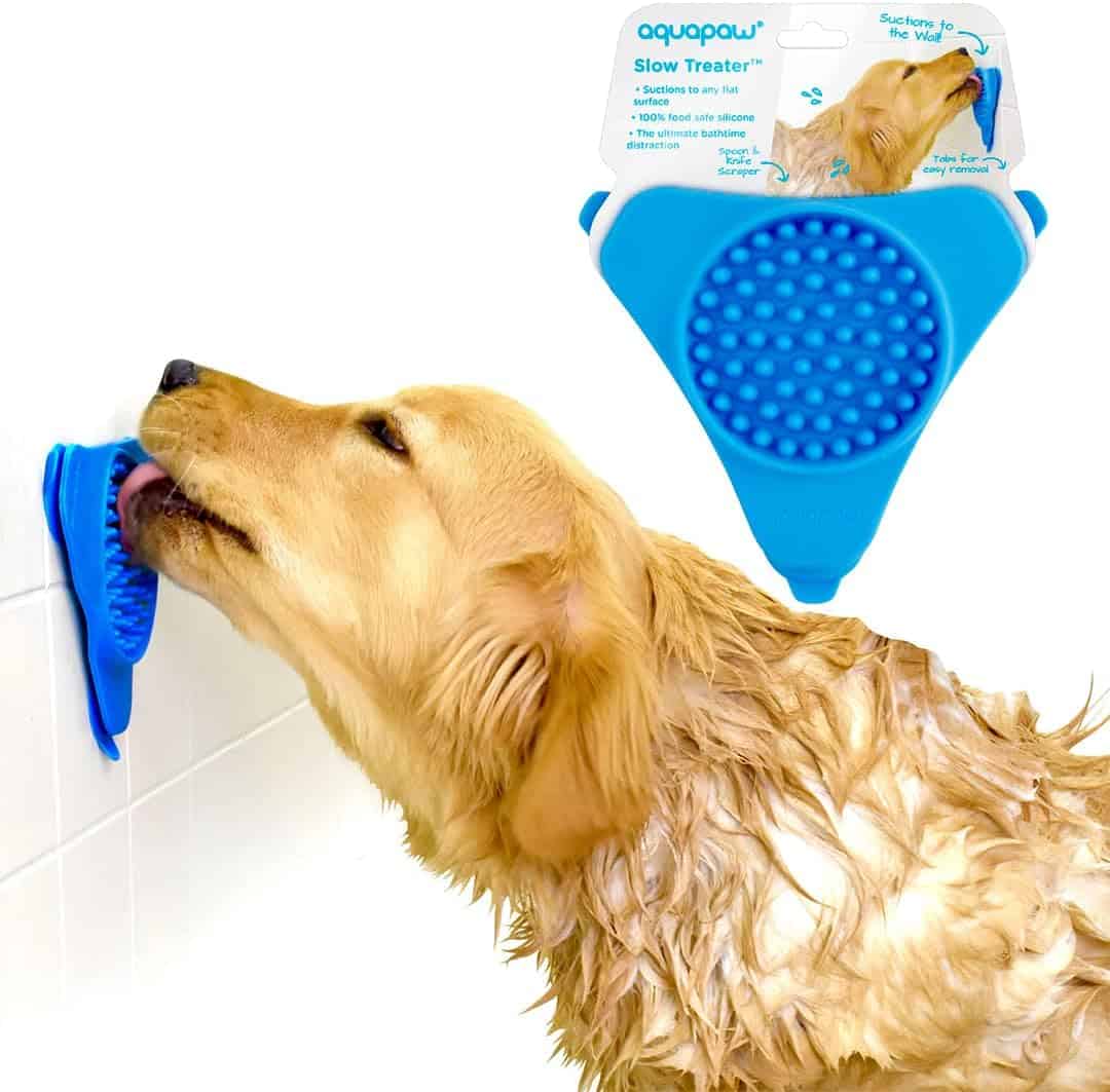 golden retriever puppy licking blue lick mat on wall