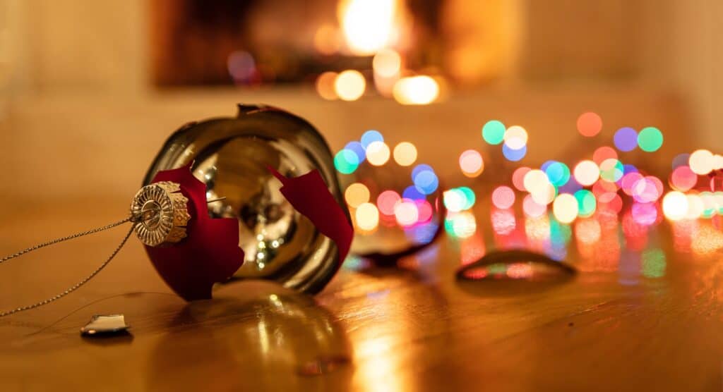 Christmas ornament broken, colorful lights glowing, blur burning fireplace background