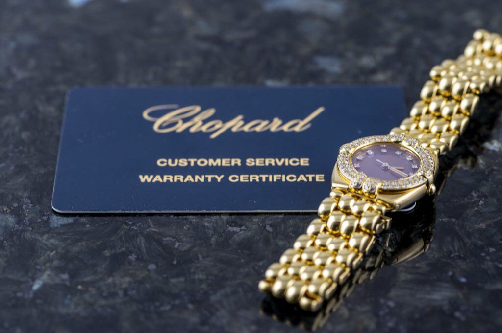 Foto einer Chopard-Uhr mit Garantiekarte aus einem Ankauf auf einem Marmortisch