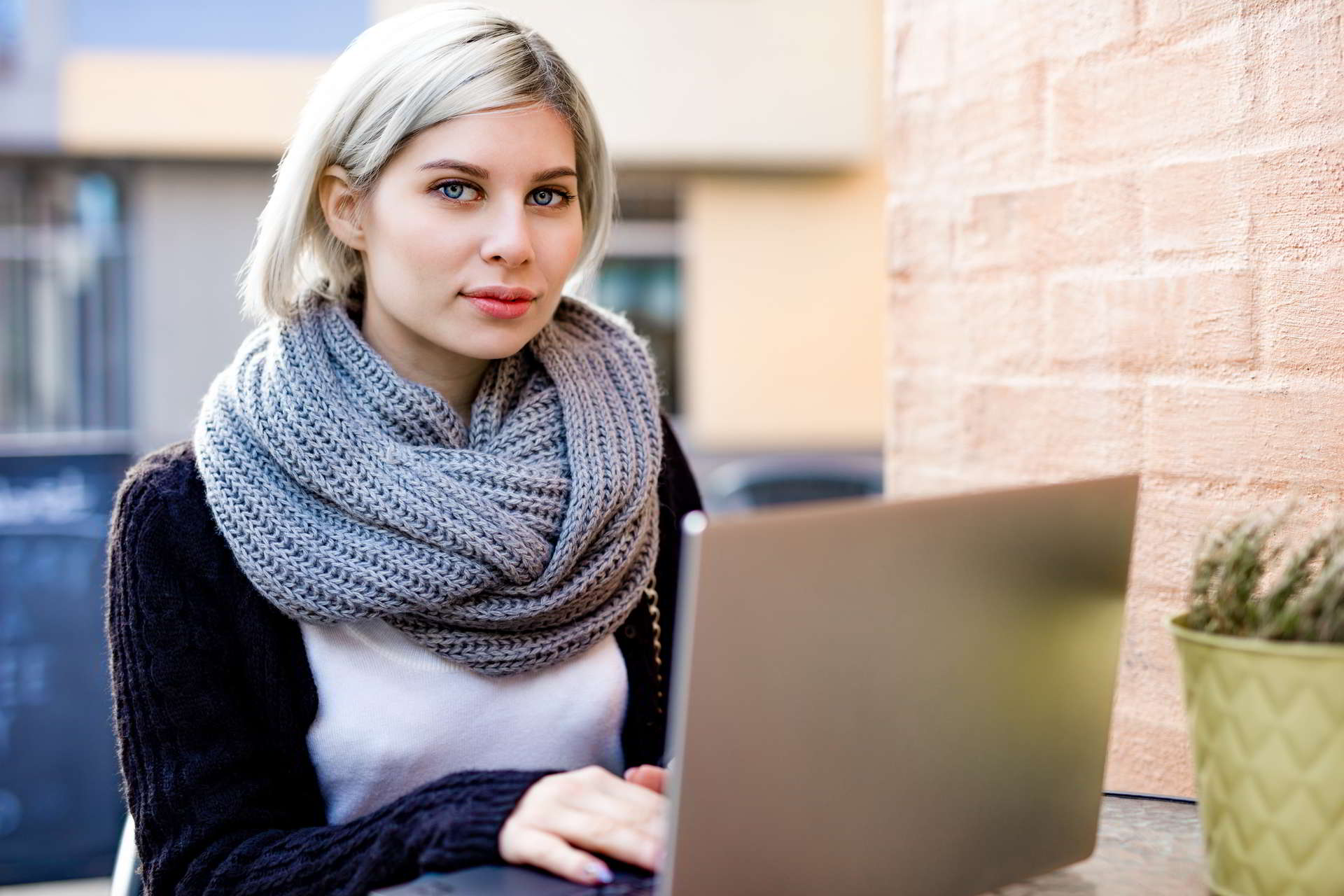 young woman working laptop outdoor cafe