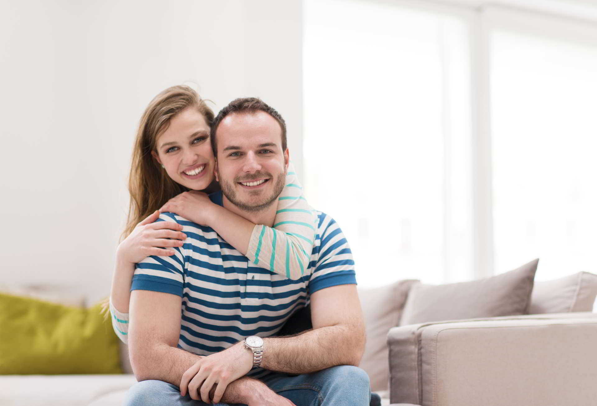 young handsome couple enjoys hugging sofa their luxury home villa