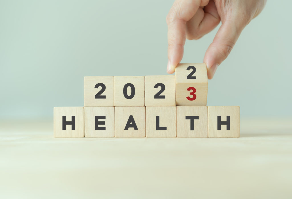 New medical conditions; Health management and trend concept in 2023. Medical healthcare business and personal healthcare. Hand flips wooden cubes 2022 to 2023 with text "HEALTH" on beautiful grey background and copy space.