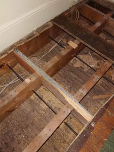 lateral restraint ties installed through floor joists to stabilise bowed wall