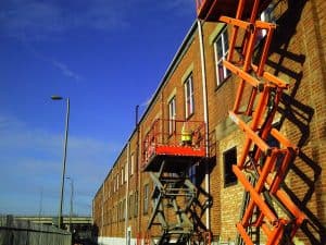 carrying out structural repairs to brick wall using a scissor lift