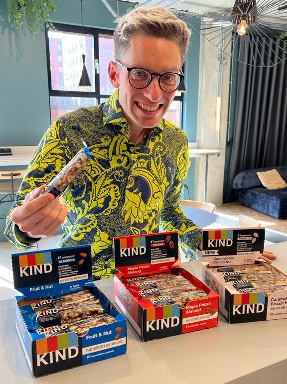 Man KIND Bar Sampling in an Office whilst smiling