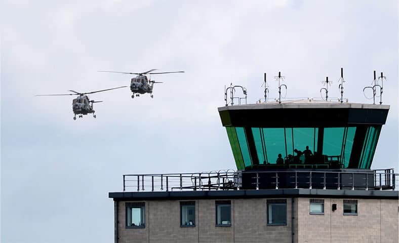 flight control tower with two helicopters flying by